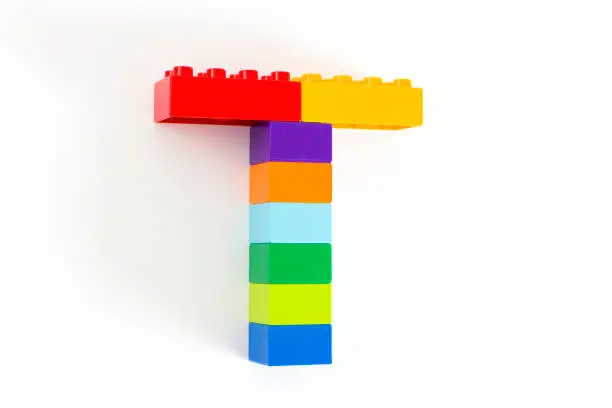 Colorful toy brick letter T isolated on the white background