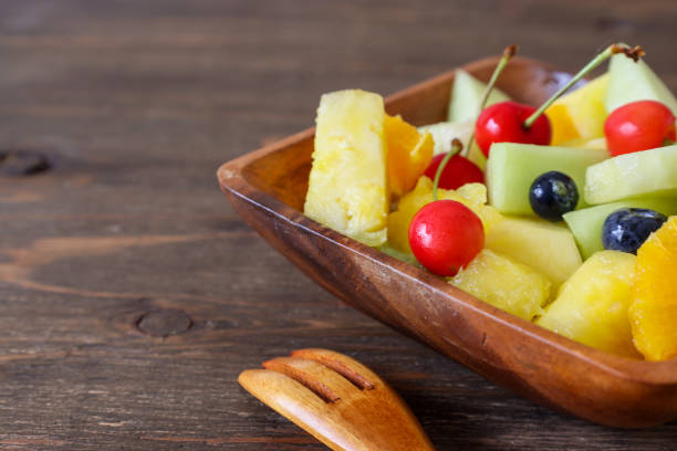 istock Small pieces of fruit cut up on a wooden bowl. 1360720258