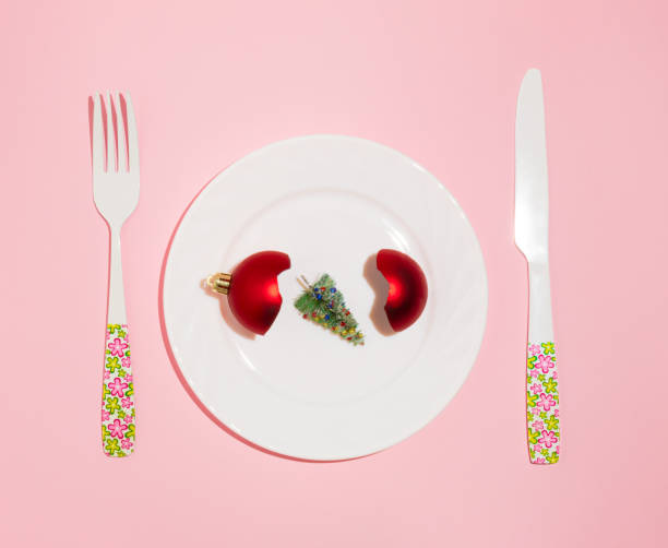 istock New Year creative layout with plate, red Christmas bauble decoration and Christmas tree. Pastel pink background. Holiday party dinner idea. 1360721867