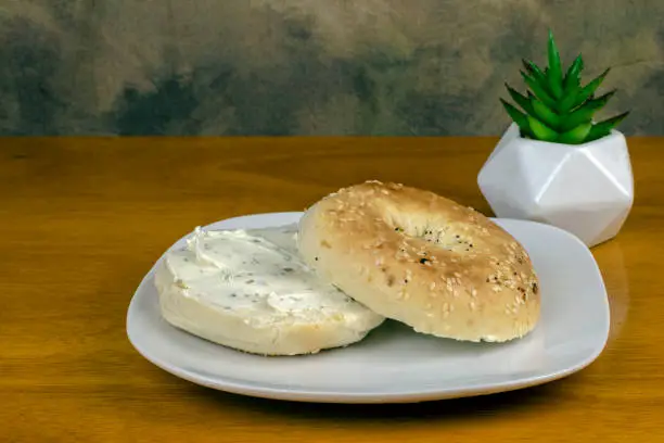 every thing bagel top with cream cheese  and served with coffee