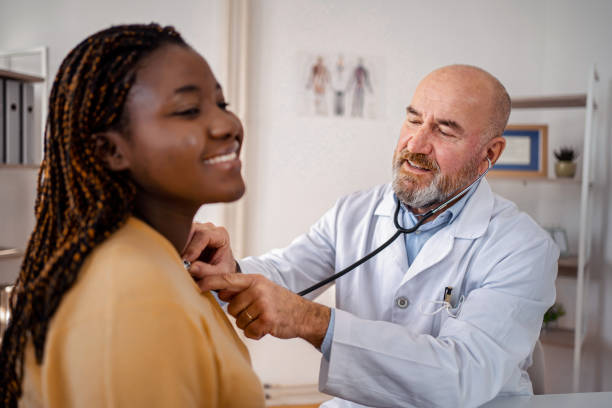 istock Experienced doctor examining black female patient with stethoscope 1360731922