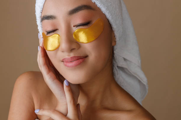 istock Asian young woman using gold under-eye patches after shower 1360735254