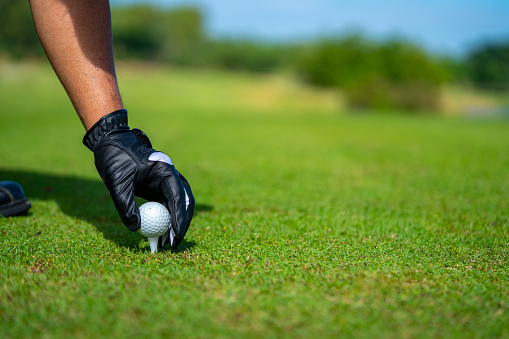 Shot of mans legs and grass while he is playing golf on the field and aiming to kick the ball