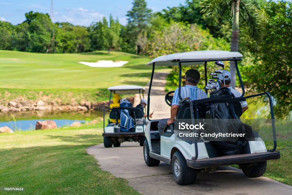 Group of Asian senior man driving golf cart on golf course in summer sunny day Group of Asian people businessman and senior CEO enjoy outdoor activity lifestyle sport golfing together at golf country club. Healthy men golfer driving golf cart on golf course in summer sunny day Golf Stock Photo