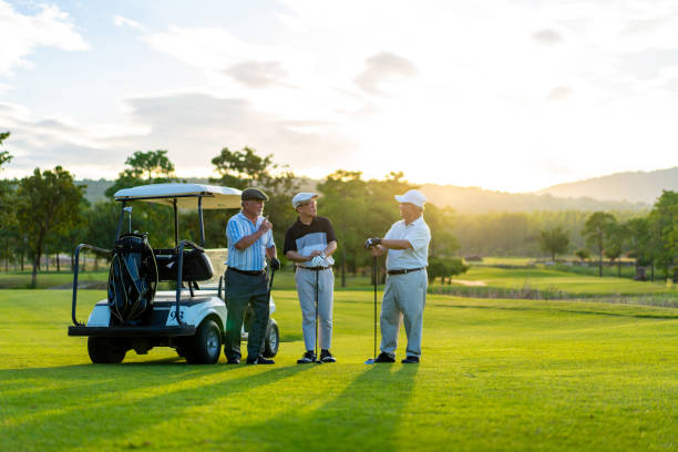 grupa azjatyckich mężczyzn golfistów ściskających dłoń po zakończeniu gry na polu golfowym o letnim zachodzie słońca - golfowy klub zdjęcia i obrazy z banku zdjęć