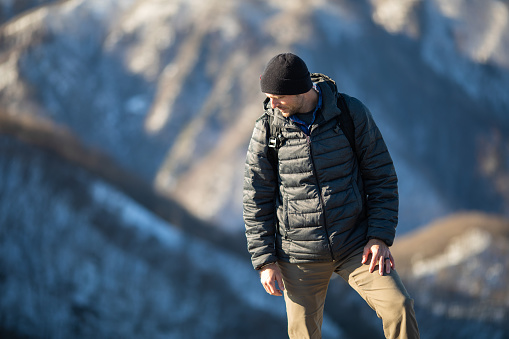 A male hiker high in the mountains on a sunny winter day.