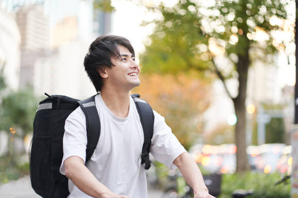 istock Asian man delivering food outside 1360753353