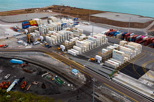 This 11 October 2020 photo shows cargo containers at the port of Lyttelton in Ōtautahi Christchurch, Aotearoa New Zealand. At the top, construction equipment is at work. The sea cargo facility is operated by the Lyttelton Port Company. The port is the largest on Te Waipounamu South Island.