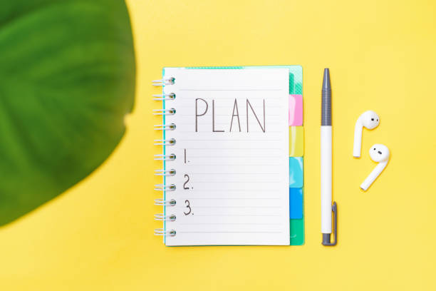 istock A notebook with a plan note lies on the table next to a pen and wireless headphones on a yellow background, close up. 1360764431
