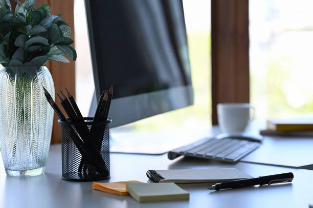 istock Computer, pencil holder and sticky notes on white office desk. 1360767338