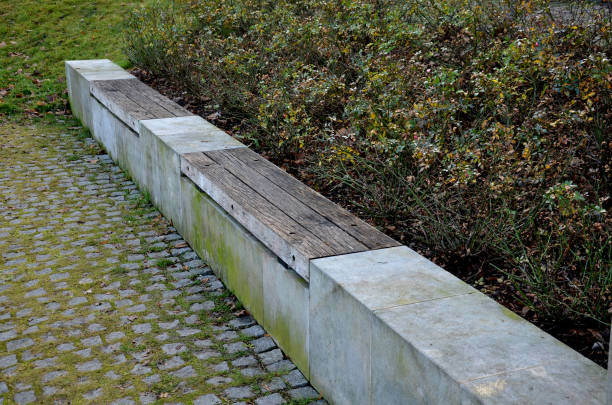 istock bent sandstone walls made of stone blocks serve as design elements, retaining walls, or seating areas, seats for park visitors. benches made of horizontal wood plank boards 1360767409
