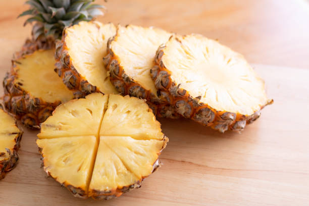 istock Pineapple slice with the knife on the wooden table 1360774656