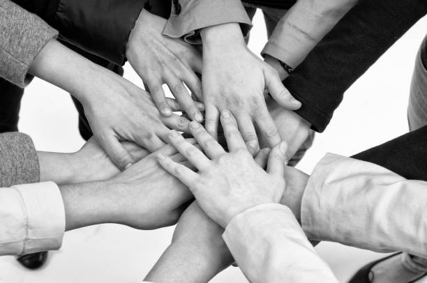 Group of people joining their hands together in a huddle. stock photo