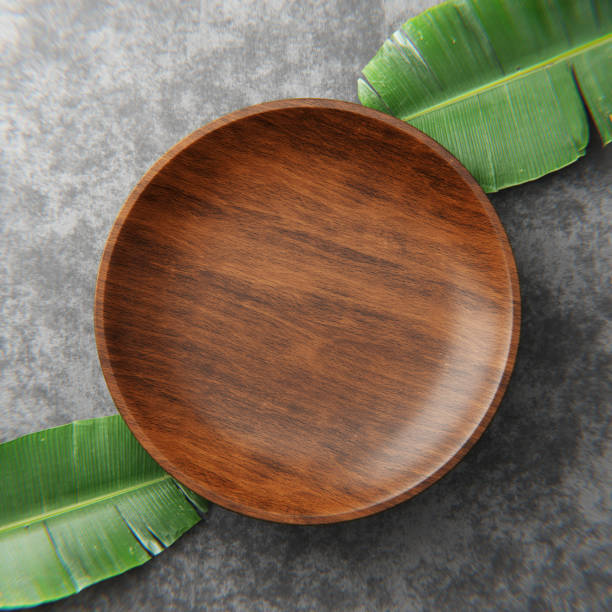 istock Wooden kitchen board. On a grey background with leaves. Top view. Free space for text. 3d illustration. 1360779659