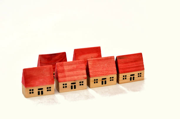 istock Six red roofed toy houses in two rows on white background 1360785075