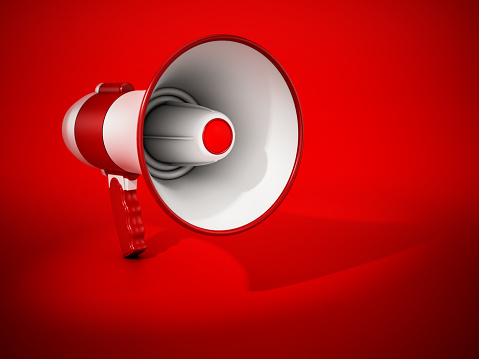 Megaphone standing on red background. Announcement and broadcasting concept.