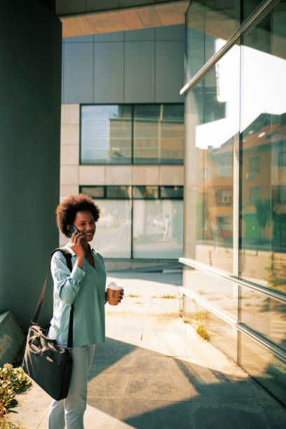 istock Young African-American woman using smart phone talking 1360785871