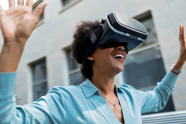 istock Woman with virtual reality glasses outdoors in front of office building 1360786021