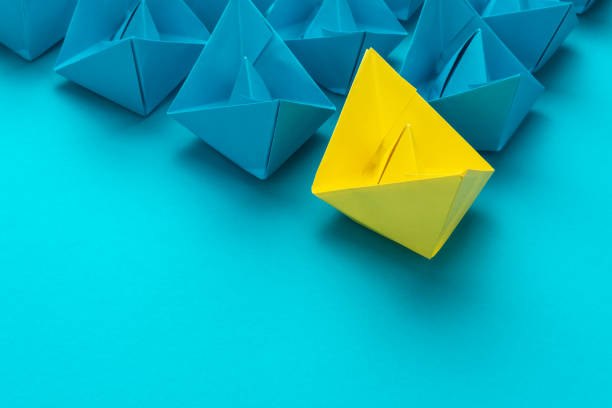istock leading yellow paper ship in leadership concept over blue background 1360789157