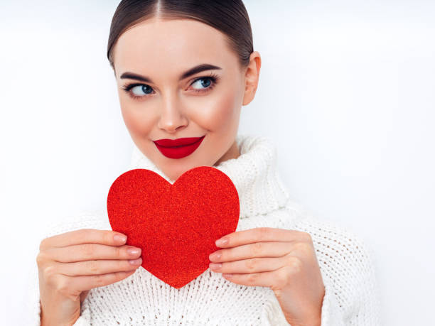 istock Beautiful young woman holding an artificial heart 1360798191