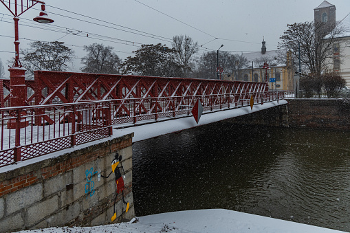 Wroclaw, Poland - December 3 2020: Sand bridge with red constructions and painting next to it full of snow at snowy weather