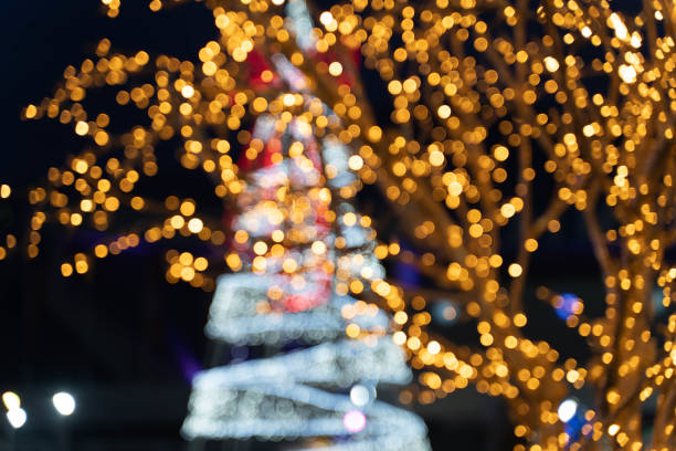 istock Blurred bokeh lights and Christmas tree behind. 1360804133