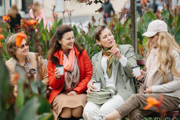 先輩女性の友人は、テラスで屋外に座って休むコーヒーを飲みます。 - bag senior adult outdoors friendship ストックフォトと画像