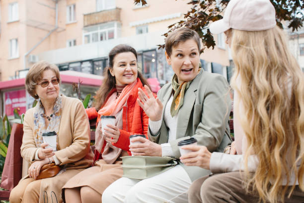 先輩女性の友人は、テラスで屋外に座って休むコーヒーを飲みます。 - bag senior adult outdoors friendship ストックフォトと画像