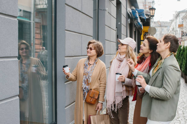 年配の女性、親友は街のショッピングの通りを歩いて楽しんでいます。 - bag senior adult outdoors friendship ストックフォトと画像