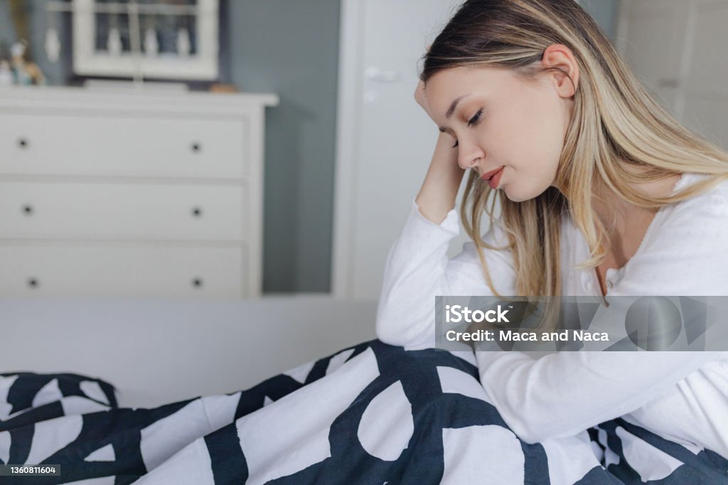 Unhappy woman suffering from depression Young woman feeling sad at home in bed Miscarriage Stock Photo