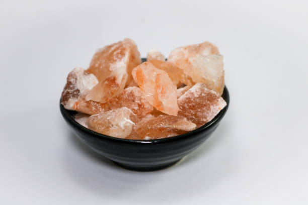 istock Himalayan pink salt pieces in black bowl on isolated white background 1360812478