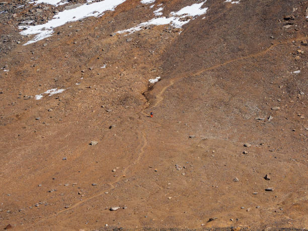 Solo trekking in the mountains. Man with a large backpack is climbing heavily on a mountain trail. Adventure solo traveling lifestyle concept, active weekend vacations on the wild nature. trekking en solitario en las montañas. hombre con una mochila grande está escalando fuertemente en un sendero de montaña. concepto de estilo de vida de viaje en solitario de aventura, vacaciones activas de fin de semana en la naturaleza salvaje.