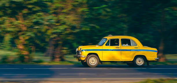 Yellow Taxi. Kolkata, India, December 01,2021: Ambassador Car made Yellow Taxi for Public transport. Panning Shot is taken. yellow taxi cab stock pictures, royalty-free photos & images