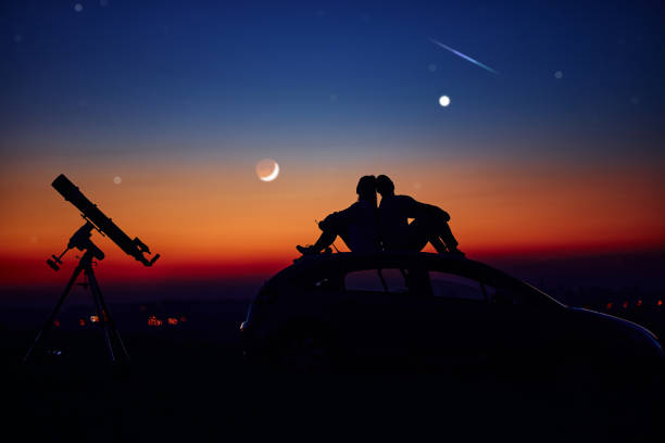 istock Couple stargazing together with a astronomical telescope. 1360817994