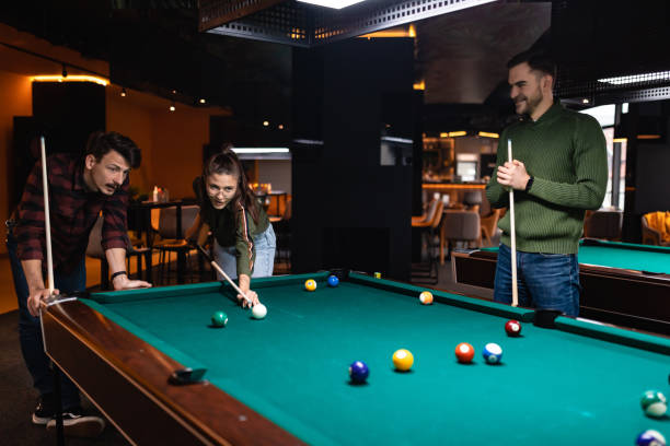 istock Cheerful best friends enjoy playing pool, in a pub downtown. 1360818619