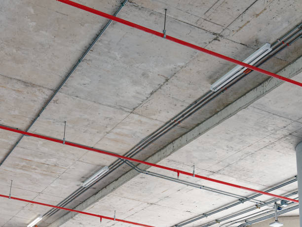 istock Low Angle View of Red Water Pipes Under Ceiling for Fire Prevention System 1360822242