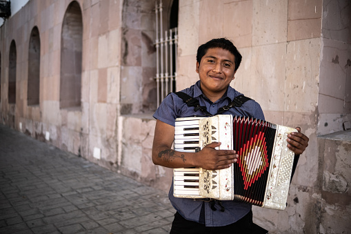 Portrait of a young man with an accordion outdoors
