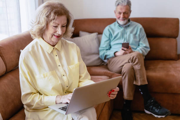 istock Senior woman is using laptop at home 1360825773