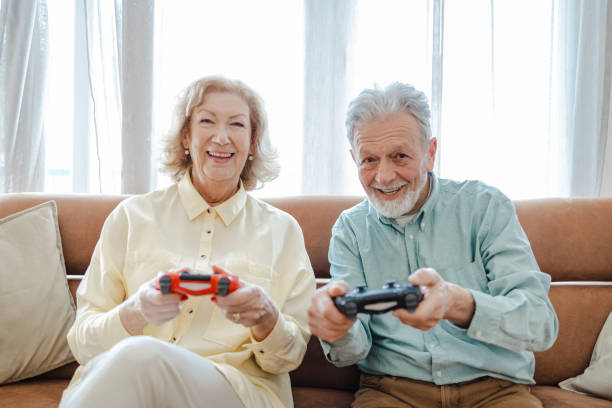 istock Excited senior couple playing video games 1360825806