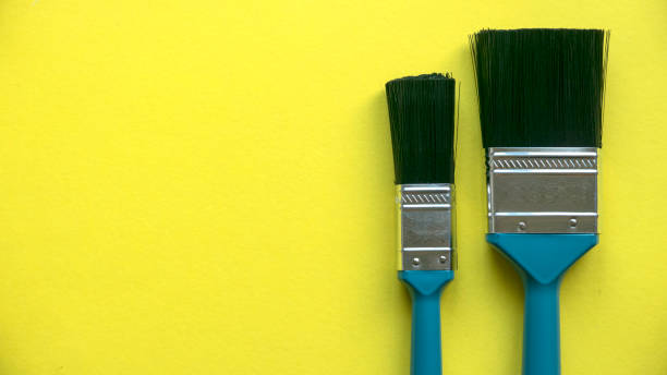 istock Paint brush on a yellow background with copy space. 1360825820