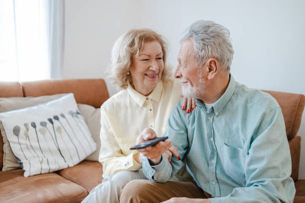 istock Senior couple at home watching TV 1360825831