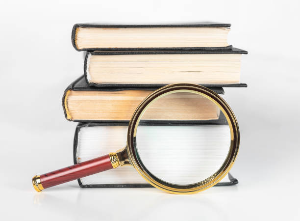 istock Magnifier and books stack. Concept of knowledge, academic research and studying. Magnifying glass and textbooks 1360825871