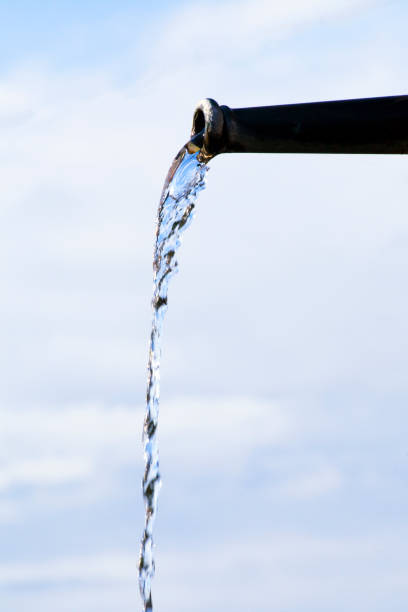 Top of a water fountain of a fountain in bright sunshine against blue skies with small white clouds