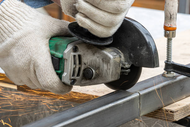 istock A man in the safety gloves is cutting metal using a green angle grinder tool with sparks on a work bench. Horizontal 1360833689
