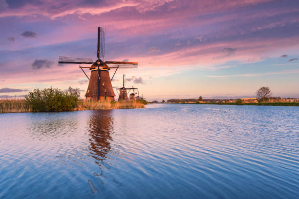Kinderdjik windmill sunrise reflection on the calm water of the Alblasserdam canal stock photo