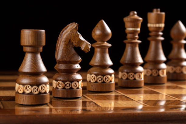 istock Chess dark pieces on a chess field. A puzzle game with tricky combinations that requires planning and thinking. 1360836071