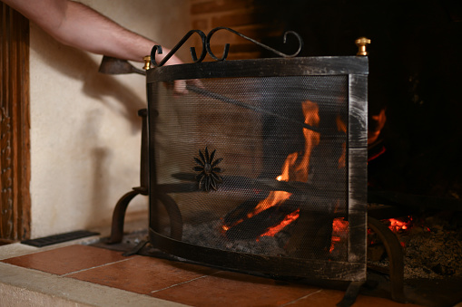 Fire in a french old fireplace with a fire shield