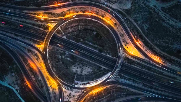 Overhead view of a large highway or highway roundabout at sunset with street lighting. Overhead view of a large highway or highway roundabout at sunset with street lighting. rotunda stock pictures, royalty-free photos & images