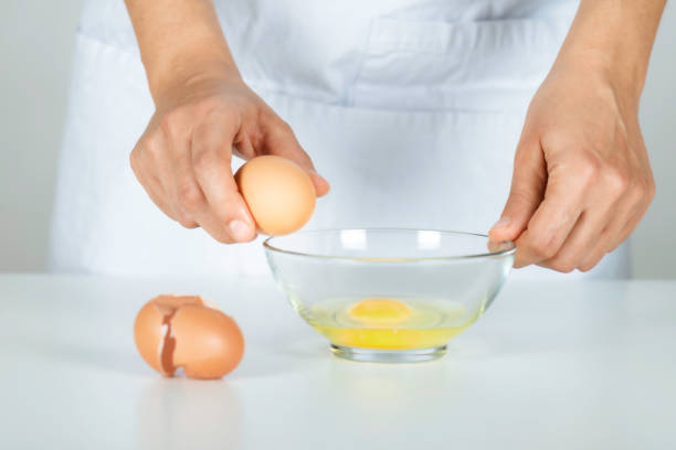istock Woman Cracking an Egg into a Bowl 1360838714