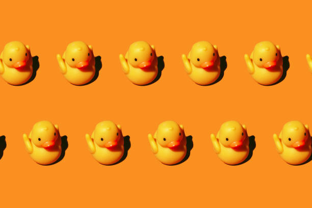 istock Seamless pattern: yellow rubber toy duck isolated on bight orange background 1360839028